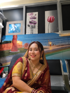 Woman smiling in traditional attire at Najma Signature Spa reception